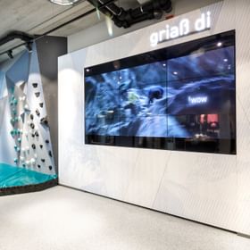 video screen next to climbing wall in the Bründl Sports Shop <br/>