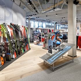 Colourful Skiwall up front, further ski equipment in the background <br/>