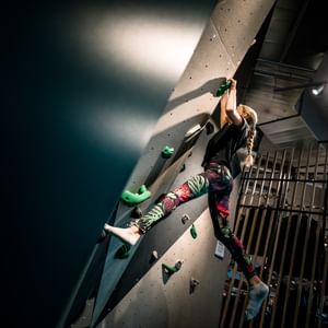 Young girl who is climbing at the Bründl Sports wall for bouldering in their shop in Saalfelden