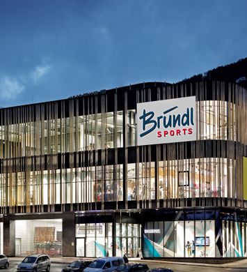 Bründl Sports Spieljochbahn Talstation well-lit shopwindow - evening view <br/>