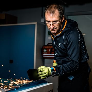 Bründl Sports employee who is preparing skis – giving off sparks