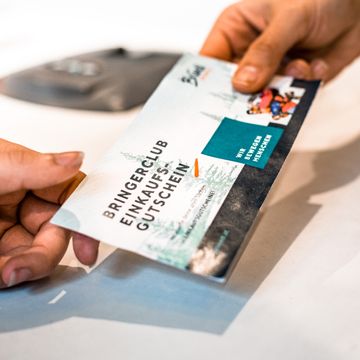 Bringerclub voucher is handed over to a customer at Bründl Sports